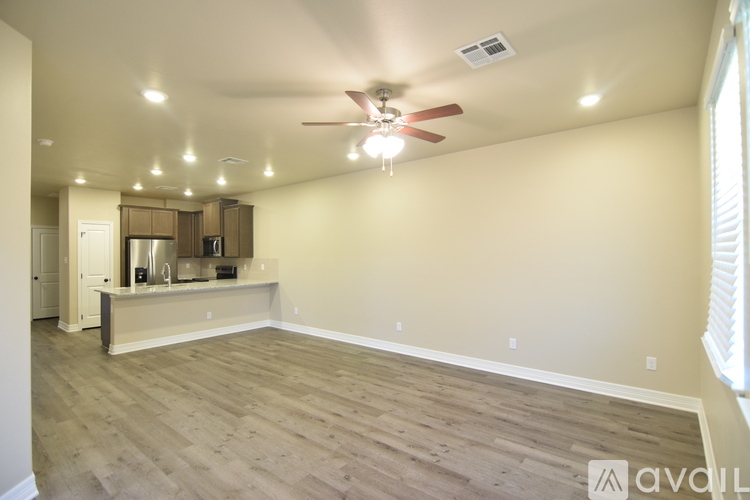 A spacious room with a ceiling fan and lighting fixtures.
