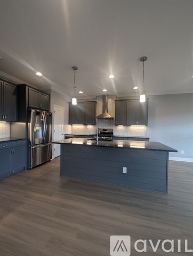A modern kitchen with dark wood cabinets and stainless steel appliances.