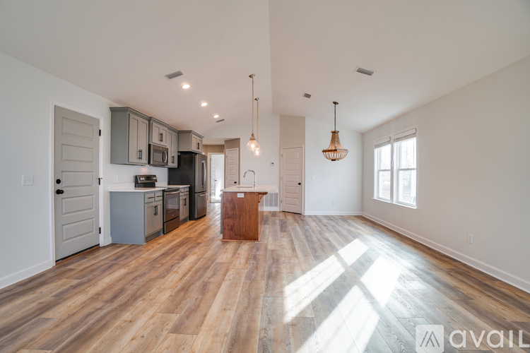 A spacious kitchen with wooden floors and a large island in the middle.