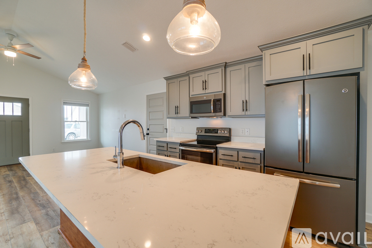 A kitchen with a marble countertop and stainless steel appliances.