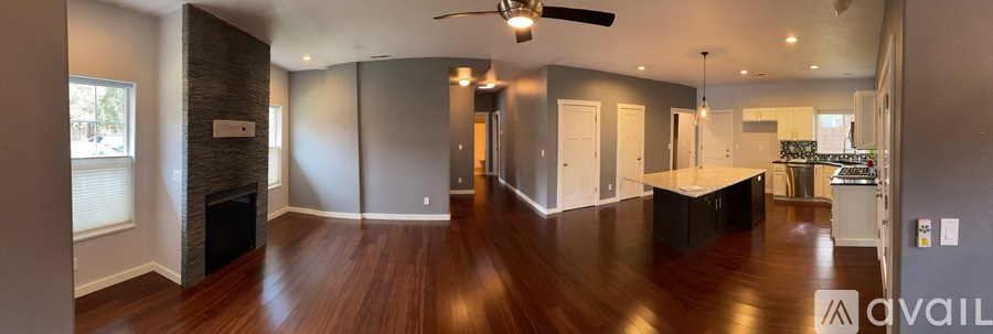 A spacious living room with wood flooring and a central island.