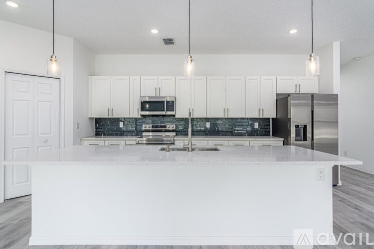 A modern kitchen with a white island in the middle.
