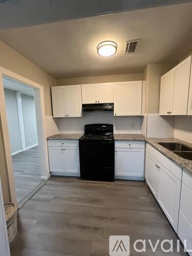 A kitchen with white cabinets and a black dishwasher.