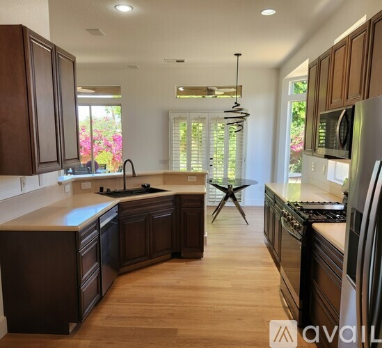 A kitchen with dark wood cabinets and a center island.