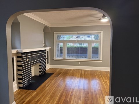 A room with a fireplace and wooden flooring.