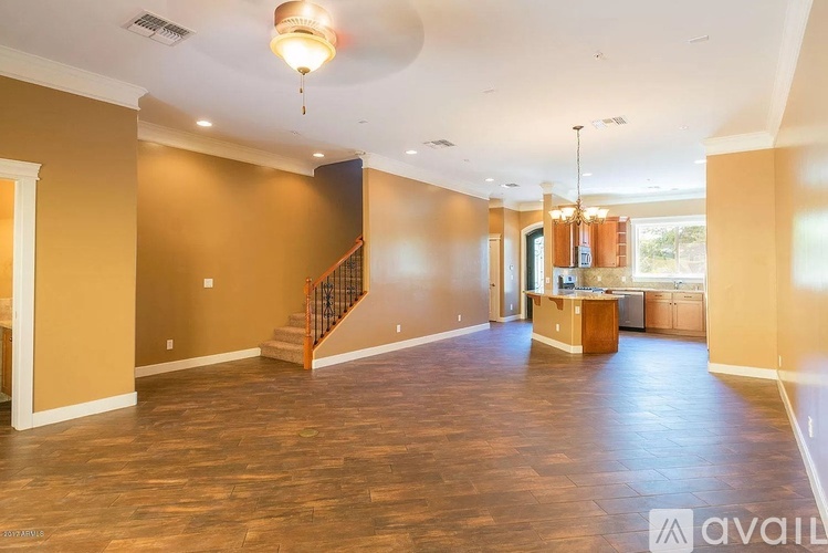 A spacious living room with hardwood floors and a staircase leading to the upper level.