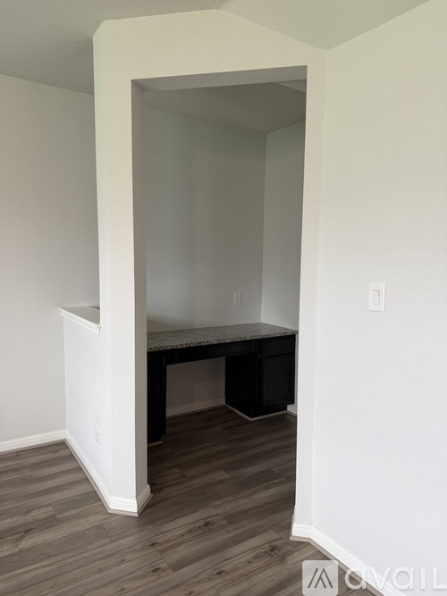 A kitchen area with a white cabinet and a black countertop.