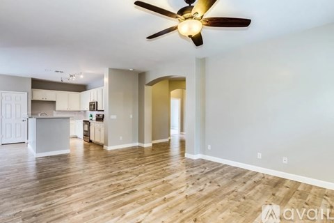 A spacious room with a ceiling fan and wooden flooring.