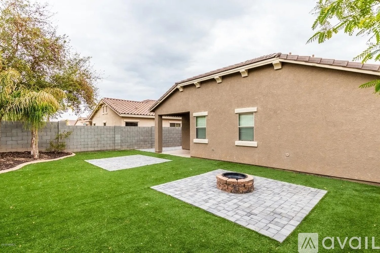 A house with a beige exterior and a green lawn.