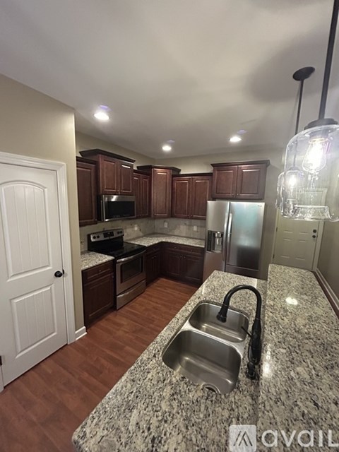 A kitchen with granite countertops and wooden cabinets.