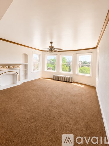 A room with a carpeted floor and a fireplace.