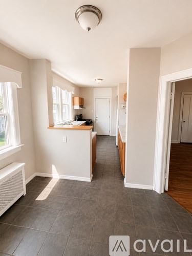 A room with a kitchen area and a dining table.