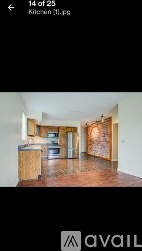 A kitchen with wooden cabinets and a brick wall in the background.