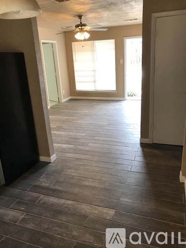 A room with wooden flooring and a ceiling fan.