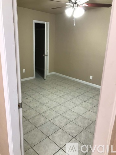 A room with a ceiling fan and tile flooring.