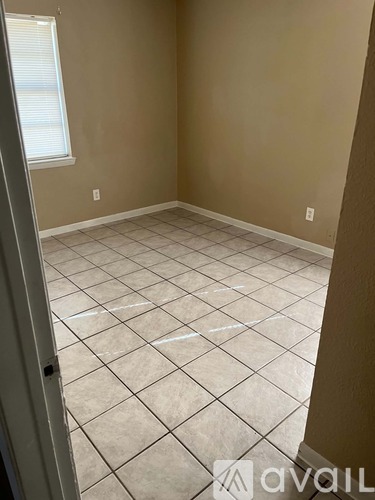 A room with beige walls and tile flooring.