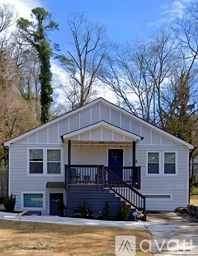 A two-story house with a balcony and a blue door.