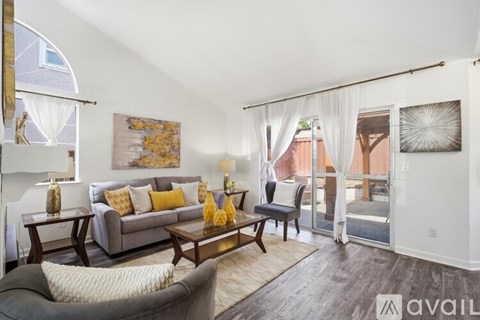 A living room with a grey couch and a wooden coffee table.