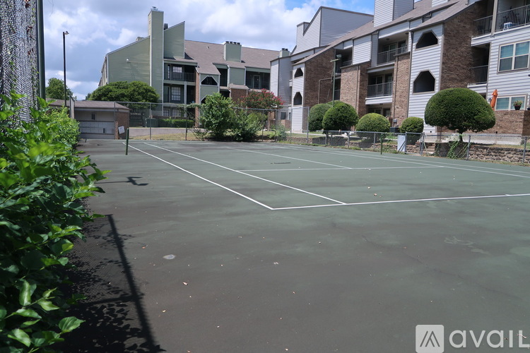 A tennis court surrounded by apartment buildings.