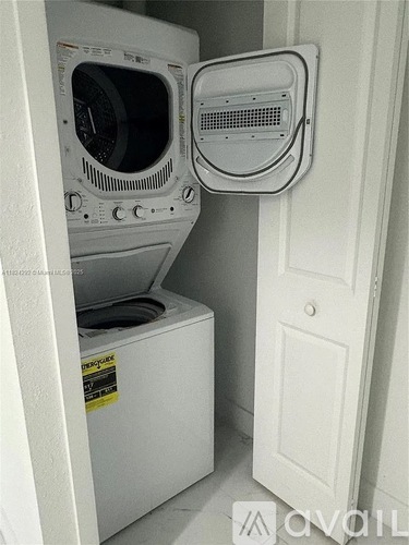 A white dryer and washing machine in a small room.