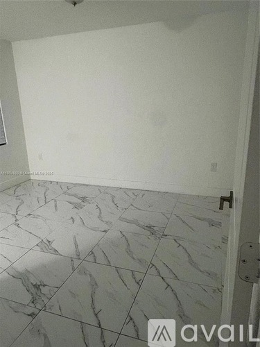 A room with a tiled floor and a door on the right side.