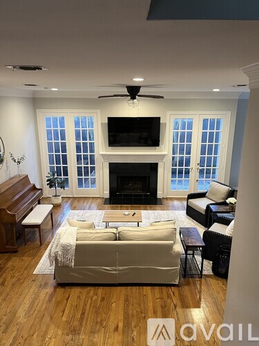 A living room with a fireplace and a television on the wall.