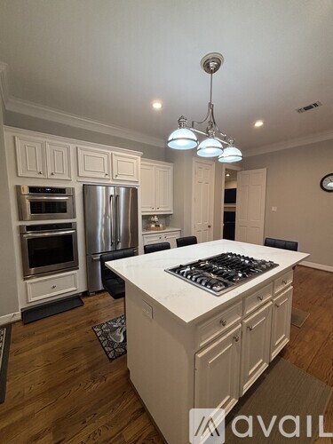 A kitchen with a white island and stove top.