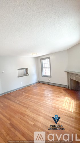 A room with wood flooring and a fireplace is available for rent.