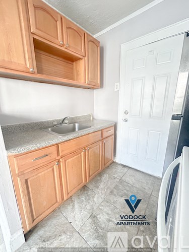 A kitchen with wooden cabinets and a white door.