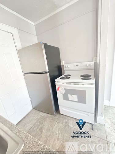 A Vodock Apartments sign is on the floor next to a stove and refrigerator.