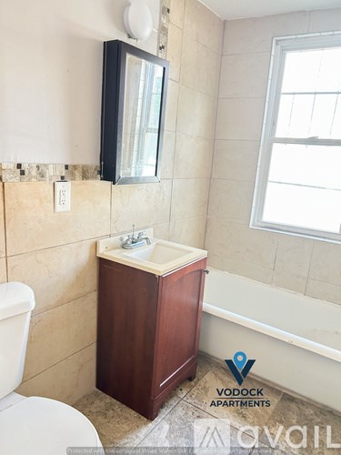 A bathroom with a toilet, sink, and mirror.
