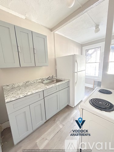 A kitchen with white cabinets and a marble countertop.