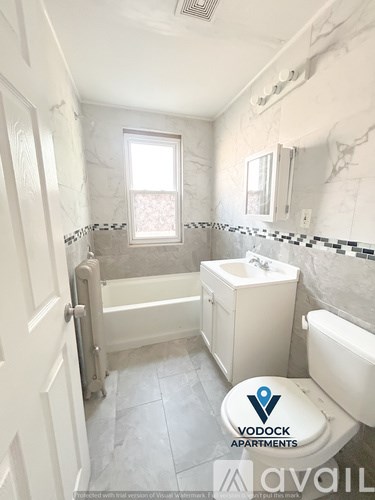 A bathroom with a toilet, sink, and bathtub.