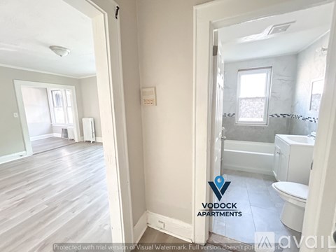 A bathroom with a toilet, sink, and bathtub is shown in a VODOCK Apartments listing.