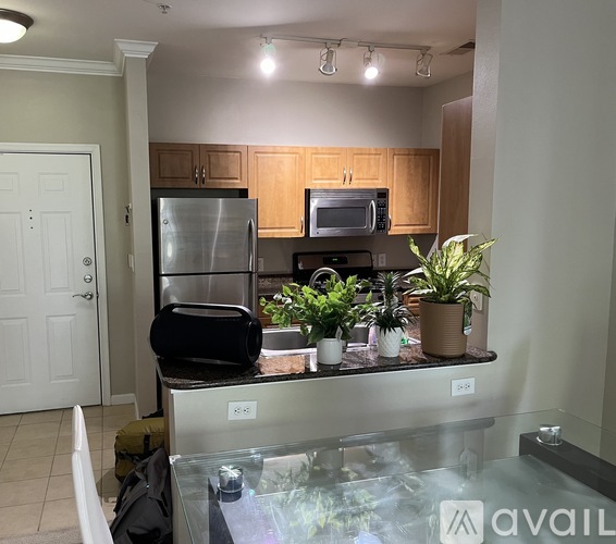 A kitchen with a refrigerator, microwave, and oven.