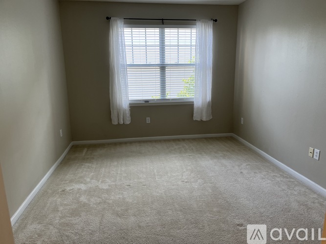 A room with a window and carpeted floor.