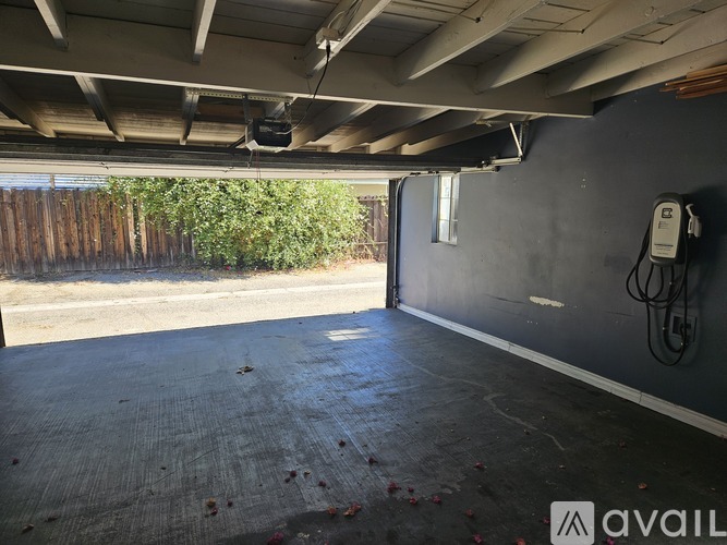 A spacious garage with a concrete floor and a wall-mounted electrical outlet.