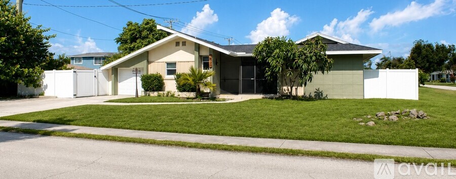 A house with a white fence and a green lawn is for sale.