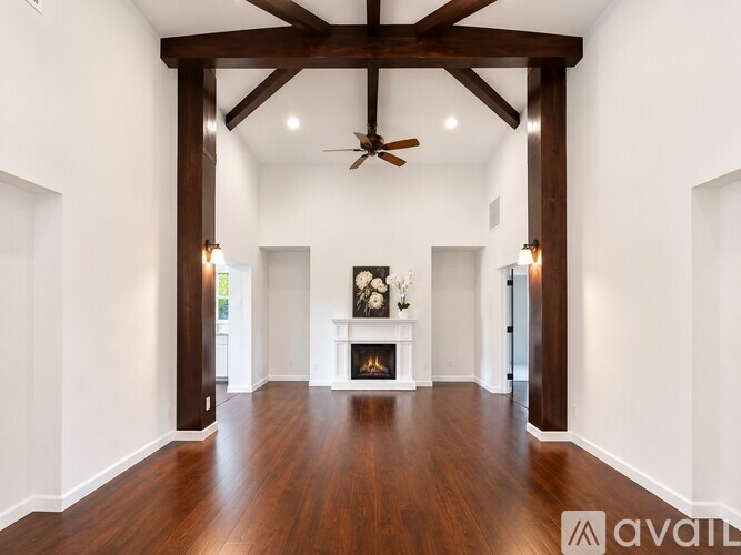 A spacious room with a fireplace and a ceiling fan.