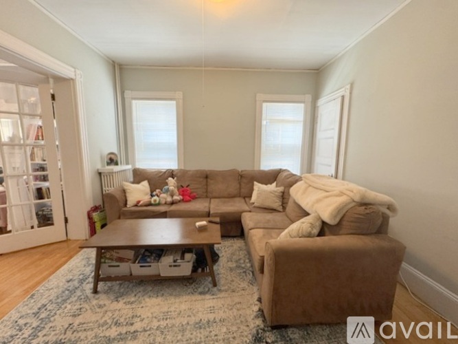 A living room with a brown couch and a coffee table.