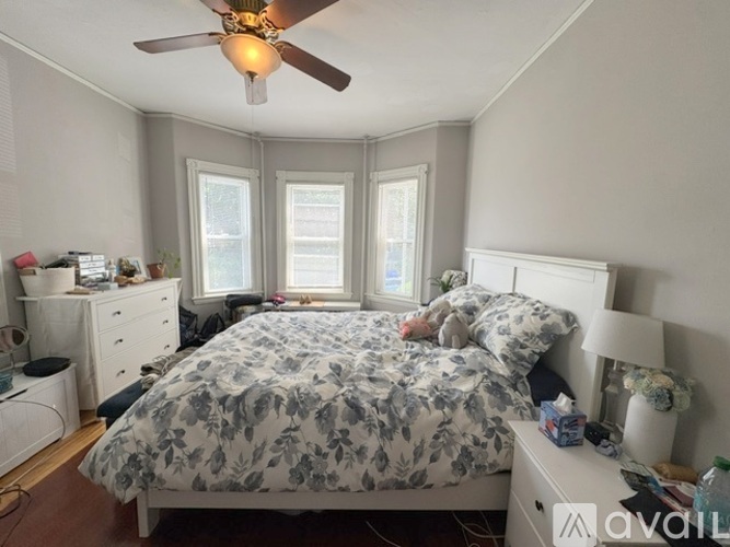 A bedroom with a bed, dresser, and window.