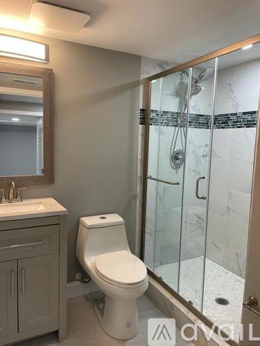 A white toilet sits in a bathroom next to a walk-in shower.