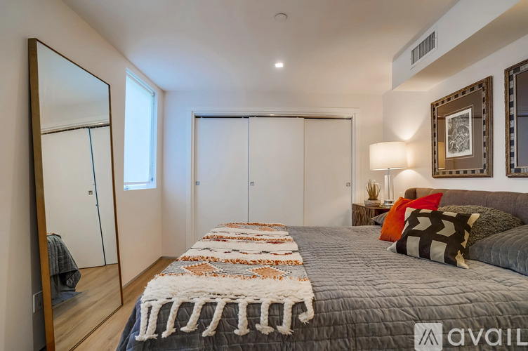 A bedroom with a large bed and a mirror on the wall.