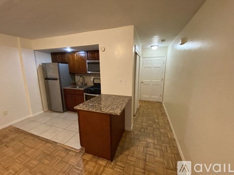 A kitchen with a granite countertop and a refrigerator.