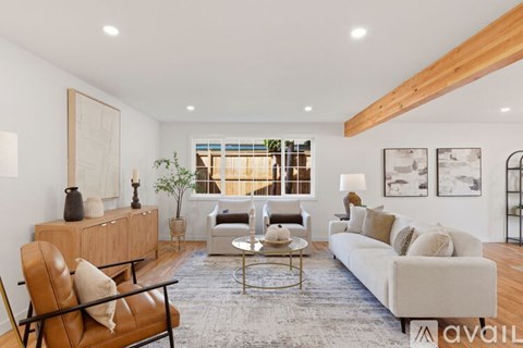 A living room with a brown leather chair and a white couch.