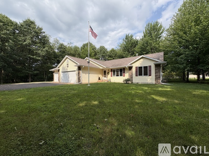 A house with a flag on the roof and a grassy yard.