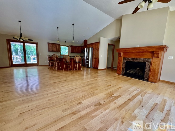 A living room with a fireplace and wooden floors.
