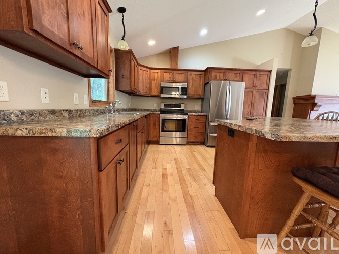 A kitchen with wooden cabinets and a marble countertop.