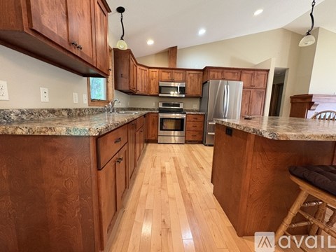 A kitchen with wooden cabinets and a marble countertop.