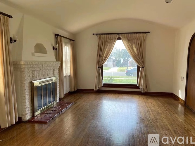 A living room with a fireplace and a large window.